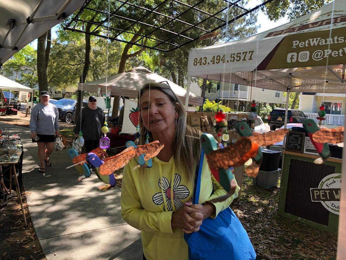 Terri Danielson of Myrtle Beach looks at artwork by Lori “Red” Varallo at the weekly Surfside Beach Farmers Market. Visitors enjoy fresh produce and local art at Myrtle Beach-area farmers markets this spring. April 11, 2023.