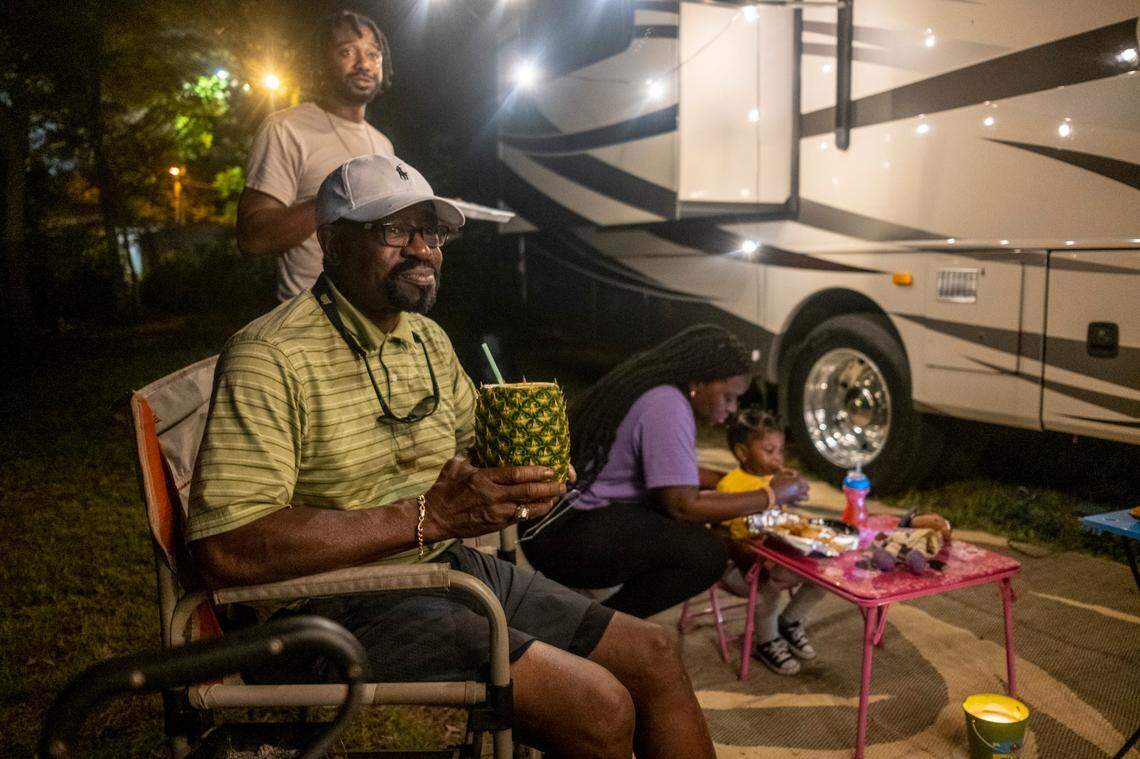 Dr. Stewart Darby, a Columbia, S.C. physician enjoys a pineapple drink while camping with his family on his empty lot in Atlantic Beach and watching the bikers on a Friday night.
