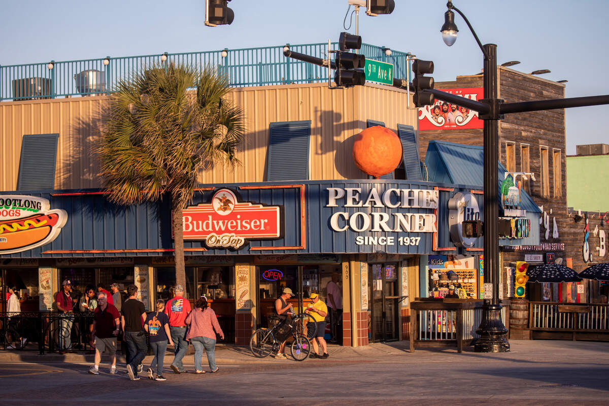 Tourists cross outside Peaches Corner in downtown Myrtle Beach.