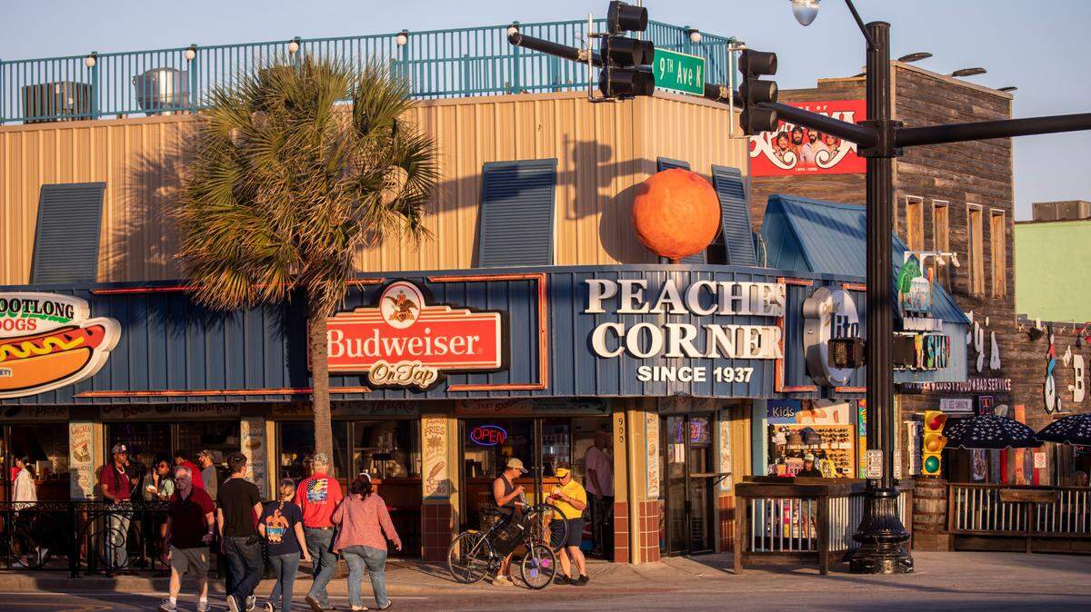 Tourists cross outside Peaches Corner in downtown Myrtle Beach, SC. File photo from March 24, 2023.