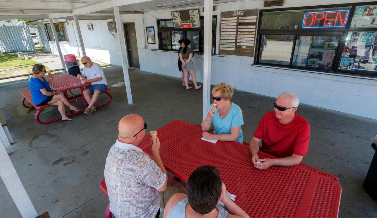 Customers sit at picnic tables outside The Original Painter’s Ice Cream in North Myrtle Beach which opened in 1952. April 22, 2022.