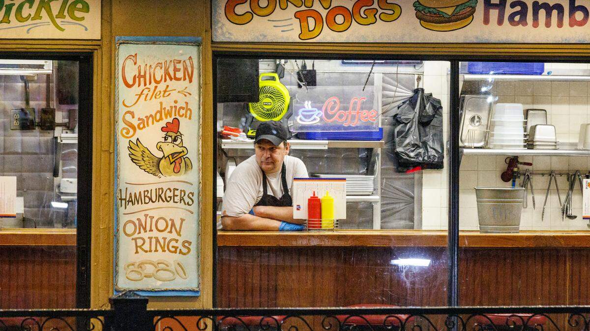 A cook at Peaches Corner awaits customers on a quiet Friday evening. Downtown Myrtle Beach’s tourist district was relatively quiet for a Summer evening on Ocean Boulevard and the Boardwalk. Storms put a damper on the evening activities but as the skies cleared, visitors returned to enjoy the attractions. Friday, May 30, 2025.