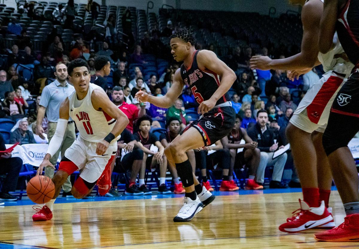 Long Island Lutheran senior point guard Andre Curbelo drives against St. John’s senior guard Ishmael Leggett on Monday night during the semifinals of the 39th Beach Ball Classic at the Myrtle Beach Convention Center.
