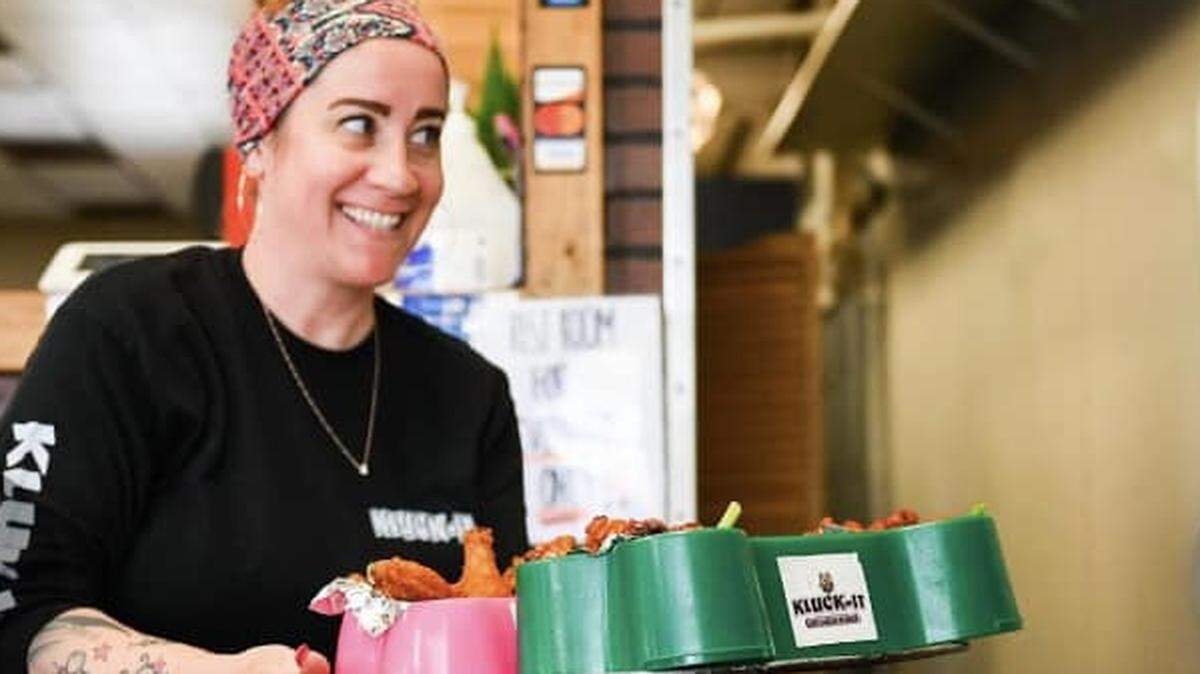 Kluck It owner Melissa Cooper-Garcia carrying a tray of chicken wings. She will be opening a second location in Conway.