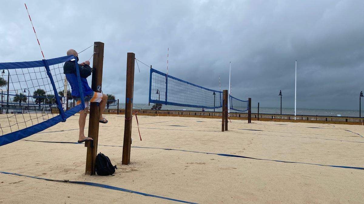 Joe Goodwin, an Horry County vollyball coach, unties vollyball nets in preparation for Hurricane Ian as strong winds batter downtown Myrtle Beach. September 30, 2022.