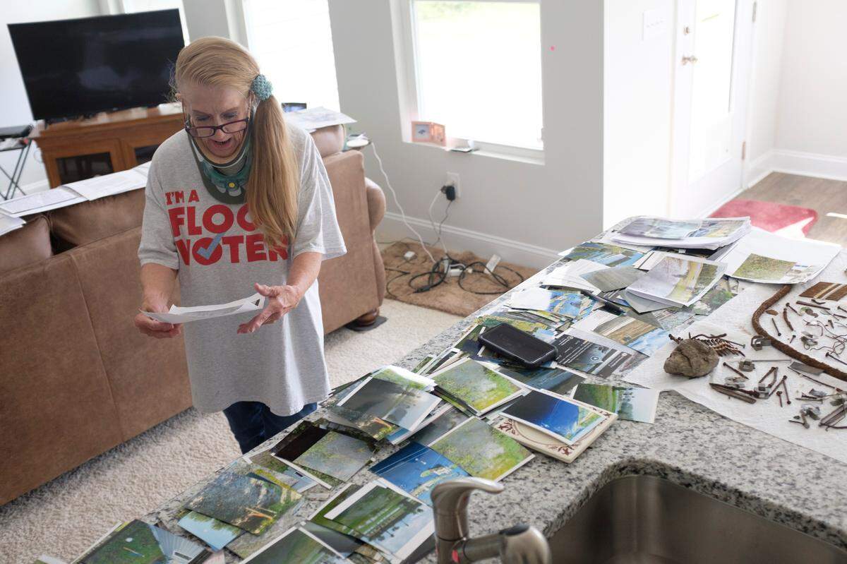 Liz Greene, a resident of River Haven, a new home development off Hwy. 9 in Longs, hanged an enlarged picture showing the subdivision’s then undeveloped lots flooded following Hurricane Florence. Greene says she was mislead into buying a property that Realtors and developers knew would flood. Aug. 11, 2021.