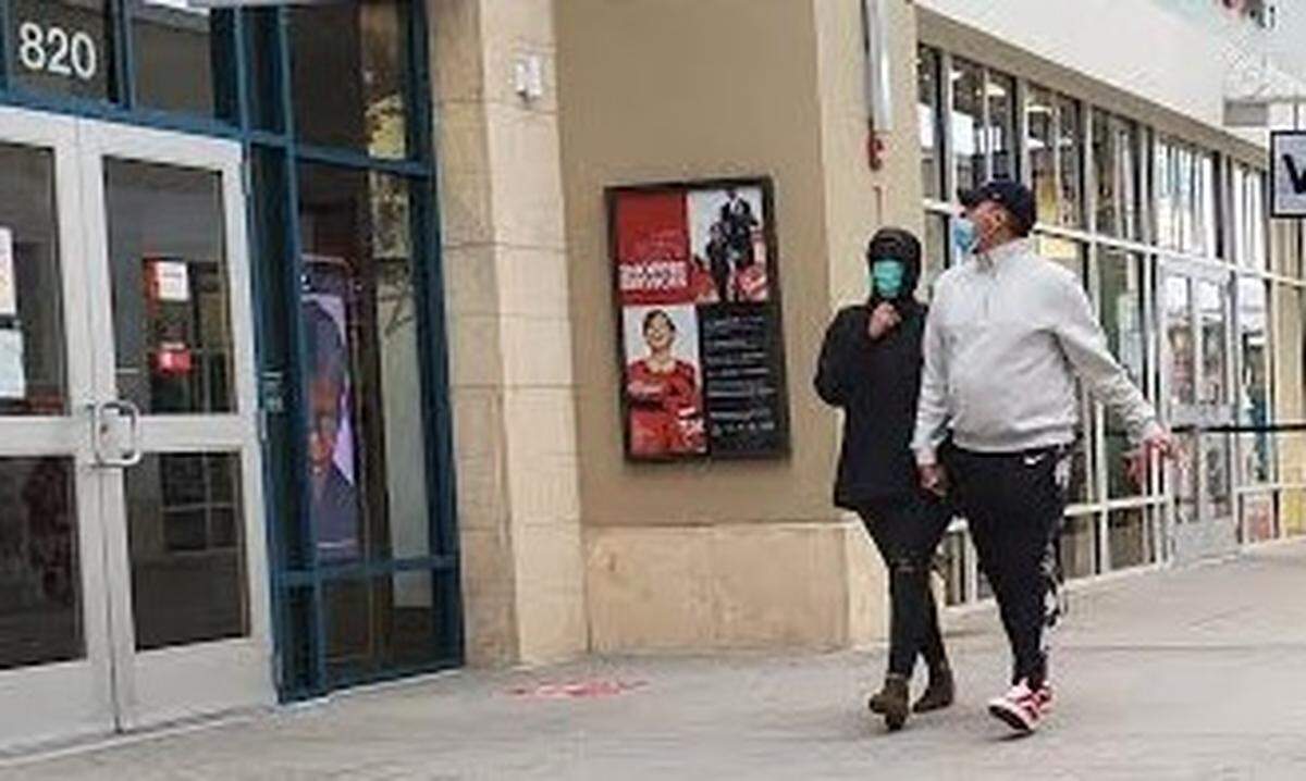 Masked shoppers walk around Tangers Outlet in North Myrtle Beach.