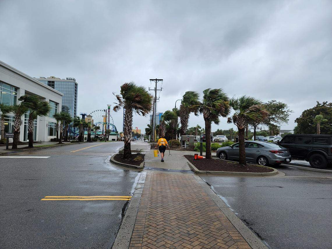 A city employee picks up trash during Tropical Storm Debby in downtown Myrtle Beach.