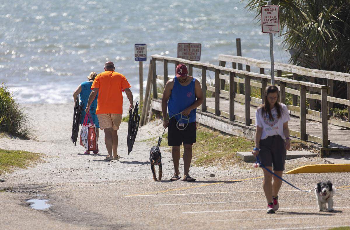 Dog walkers and beach goers walk down a beach access at 77th Avenue North in Myrtle Beach, S.C. in 2020.
