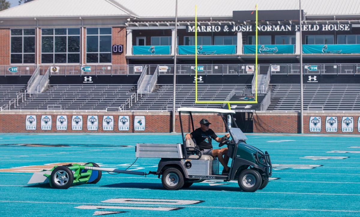 Jeff Grant a grounds keeper for Coastal Carolina, pulls the “litter cat” across the field. The device vibrates to pull loose items from the thatch of the artificial turf at Brooks Stadium. Sept. 30, 2024.