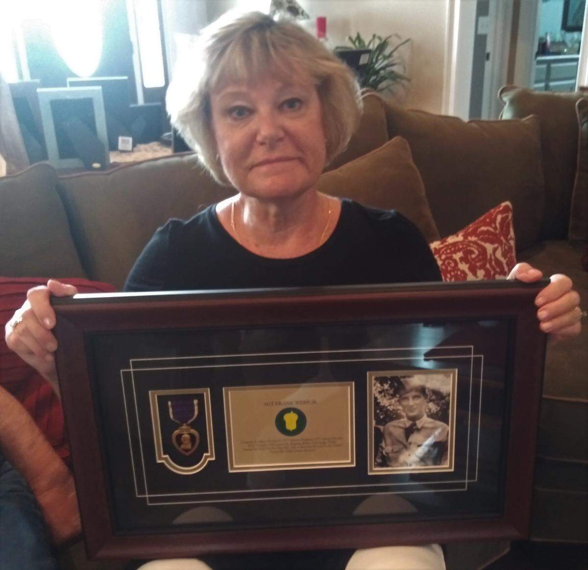 Carolina Forest resident Laurie DiLorenzo shows off the framed Purple Heart her uncle was awarded after receiving it from Purple Hearts United on Saturday.