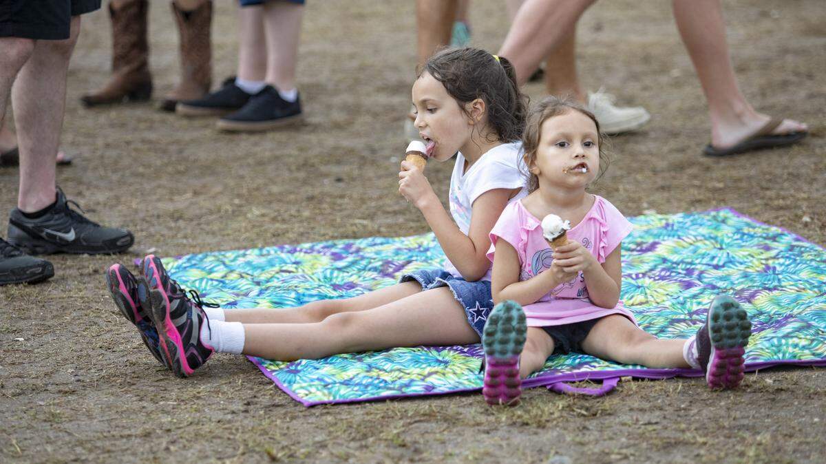 Ava Johnson, 8 (L), and Sirena Johnson, 4, of Charlotte, N.C., eat ice cream at the 2019 Carolina Country Music Fest in Myrtle Beach.