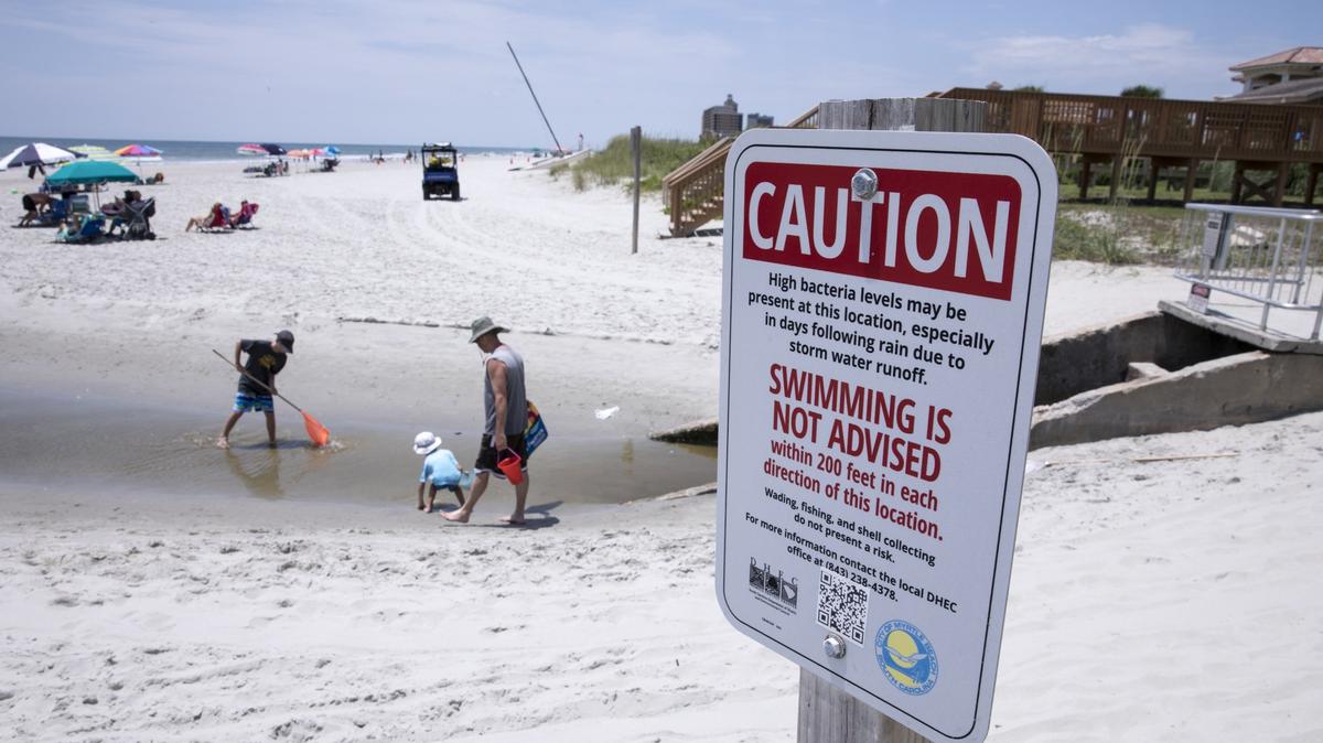 Children play in the Cane Patch Swash in Myrtle Beach. DHEC warns against swimming in swashes and in the outflow of storm water pipes. Long-term swim advisory signs are placed in many areas along the Myrtle Beach coast.