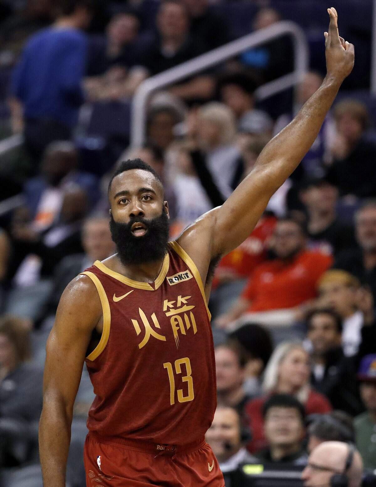 Houston Rockets guard James Harden (13) signals after making a three-pointer against the Phoenix Suns during the second half of an NBA basketball game,, Monday, Feb. 4, 2019, in Phoenix. (AP Photo/Matt York)