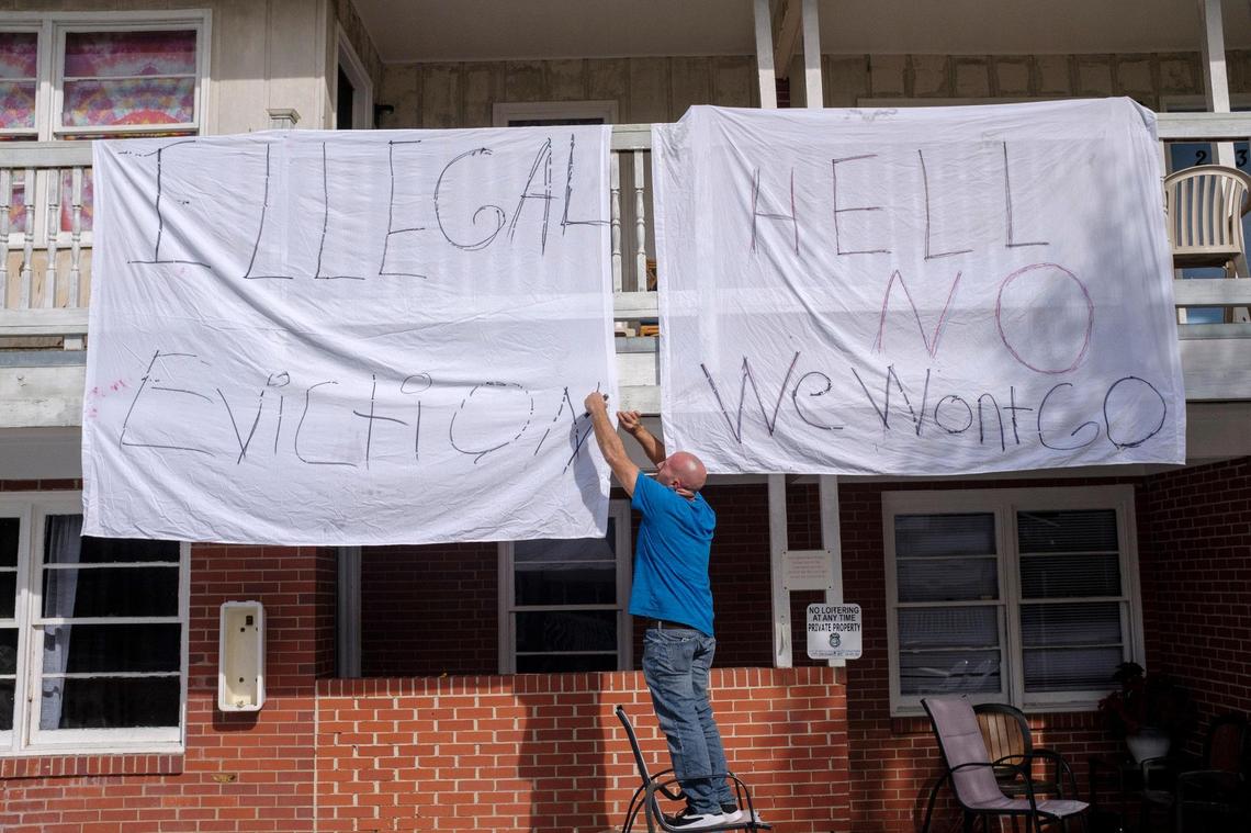 Robert Dunn, a former employee and long term resident of the Aquarius Motel in Myrtle Beach hangs banners from the balcony. December 3, 2020.
