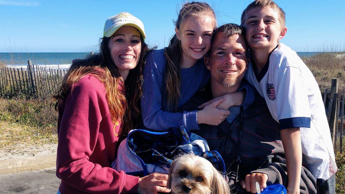 Chris Skinner, his wife Suzie, and their 12-year-old twins and family pet dog pose for a picture with Skinner on his new TracFab all-terrain wheelchair near the beach in Myrtle Beach.