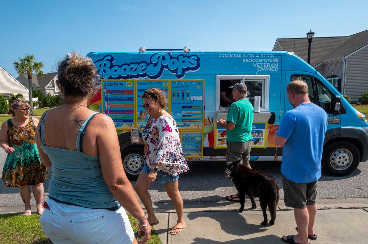 Neighbors gather around the Booze Pops truck when it makes a stop in the Forestbrook community of Tuscany on Cinco de Mayo. With most of the spring events canceled in the Myrtle Beach area, the Booze Pops truck has been making the rounds of local communities, “bringing the bar” to people stuck at home. May 5, 2020