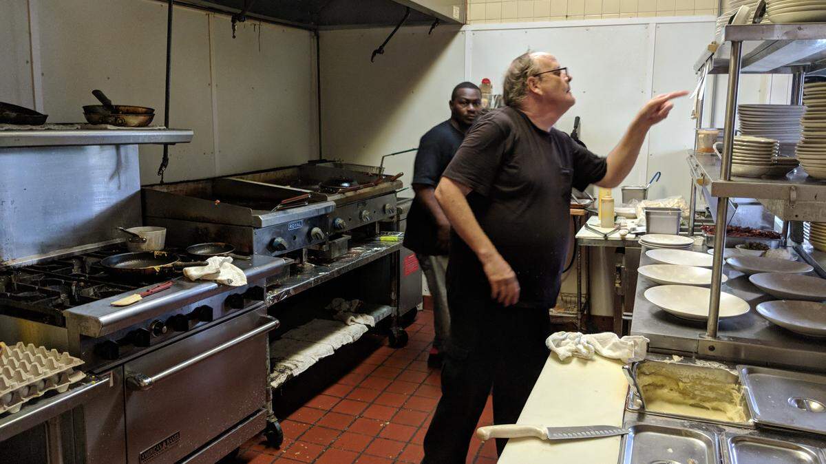 Ernie Ross, owner of Ernie’s Diner, prepares food for customers Thursday. He hopes to keep cooking through the storm.