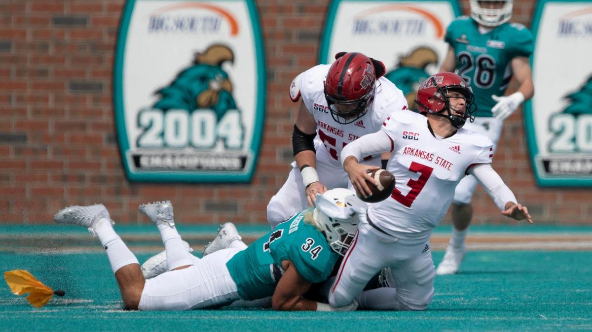 Arkansas State’s Layne Hatcher is brought down by Coastal’s Teddy Gallagher. Coastal Carolina played Arkansas State in its 2020 Sun Belt Conference football opener on Saturday at Brooks Stadium in Conway.. October 3, 2020.
