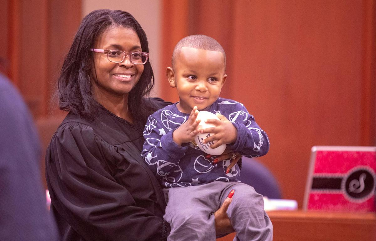 Family Court judge Jan Bromell Holmes holds Frankie Robinson, Jr., 2, after he was adopted by his parents, Frankie and Keisha Robinson Monday at the Horry County Courthouse in Conway.