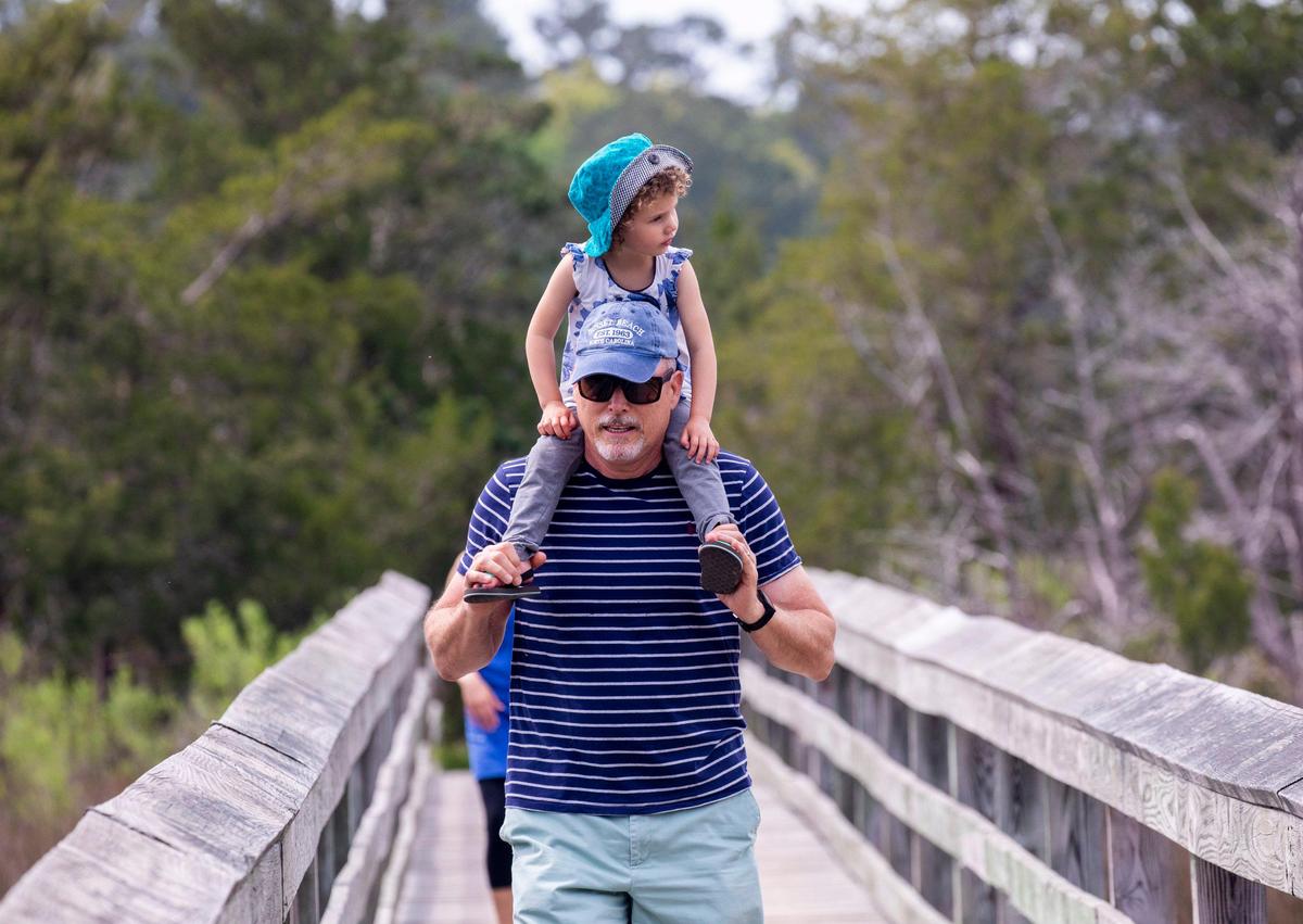 John Phillip Zell carries his daughter Elouise on his shoulders at Vereen Memorial Gardens on Tuesday. Locals around the Grand Strand were enjoying the Spring weather on Tuesday by getting outside. South Carolina’s Governor Henry McMaster toughed his “work or stay home” order this week In response to the coronavirus, but he made allowances for recreational activities. April 6, 2020