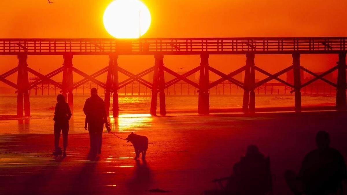 Beachgoers enjoy a November sunset in the Cherry Grove section of North Myrtle Beach on Friday, Nov. 18, 2016. The National Weather Service is predicting a dry winter this season.
