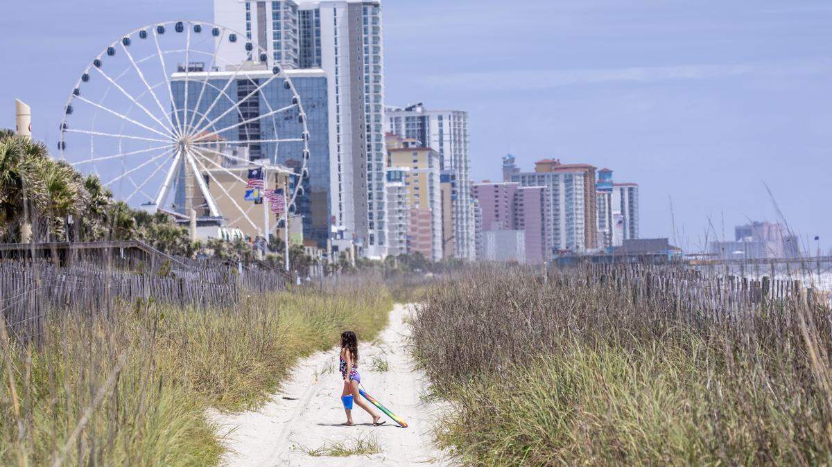 Demi Desoto crosses a Myrtle Beach access to join her family. The Desoto family made a day trip from Darlington to enjoy the beach on Wednesday. Public beach accesses have re-opened in Myrtle Beach after being closed for weeks due to the coronavirus. Myrtle Beach, S.C. April 29, 2020