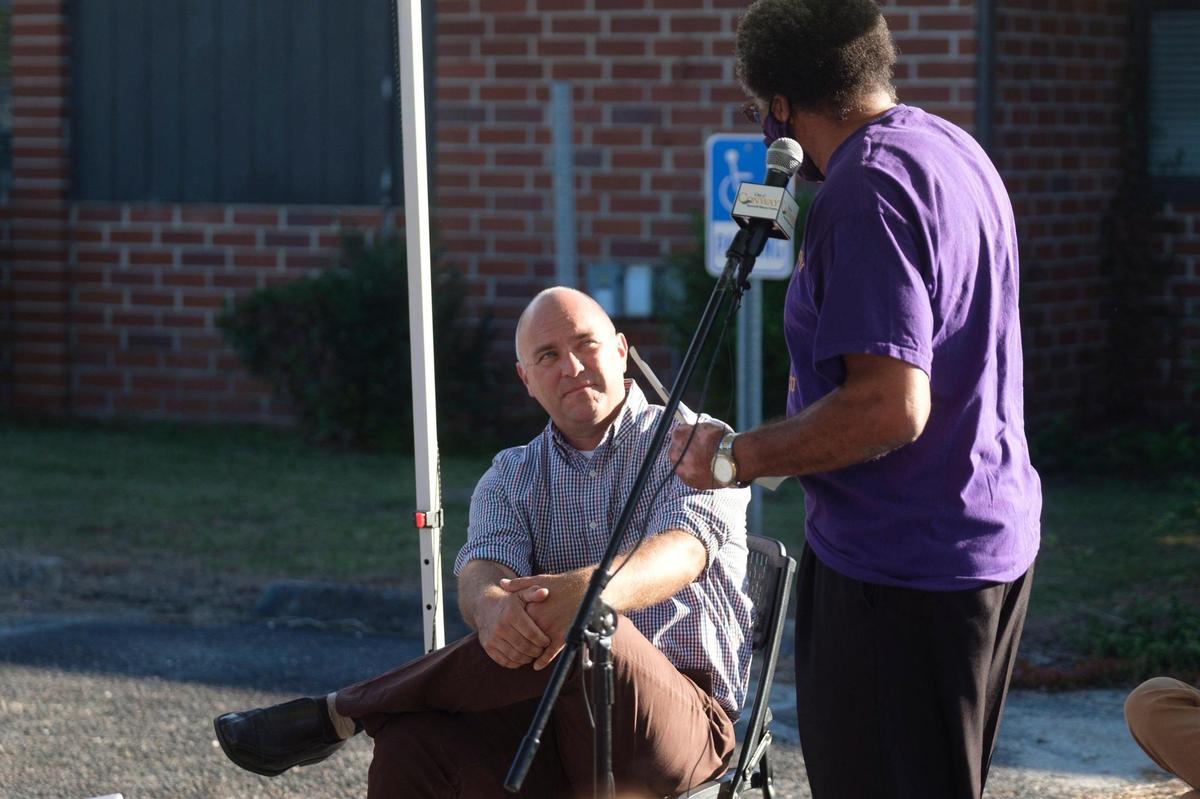 Members of the Conway community, many wearing school colors, listen to an explaination by Conway city administrator Adam Emrick of why the historically black Whittemore Elementary School will likely need to be demolished despite outspoken former students fighting for preservation. Oct. 27, 2021.
