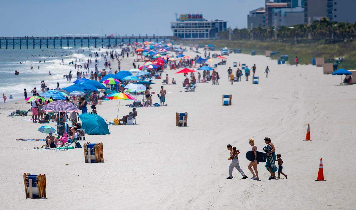 People walk onto the beach in Myrtle Beach Saturday afternoon.