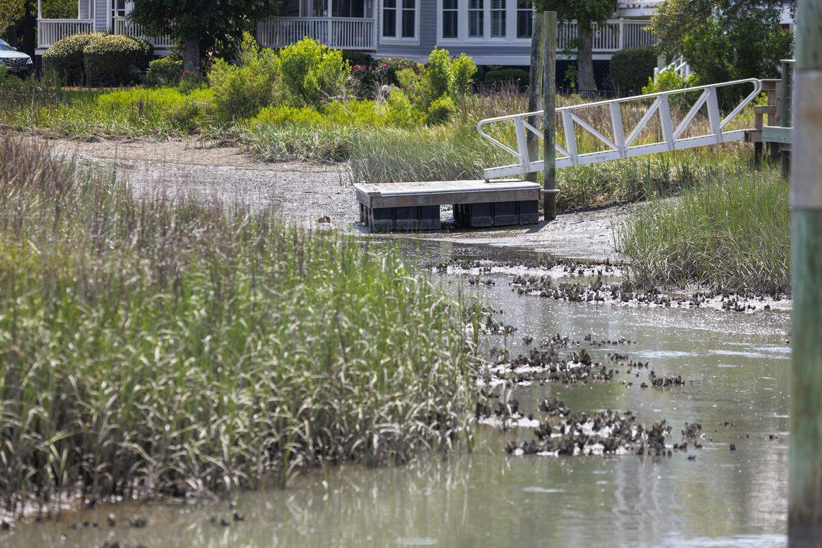 A dock sits on the mud during low tide in Murrells Inlet on May 22, 2026. A dredging project would improve access to boaters but has run into controversy. Estuaries like Murrells Inlet are among the most biologically productive ecosystems and serve as vital nurseries where many marine species begin their lives.