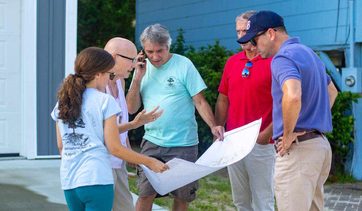 North Myrtle Beach residents look over plans as crews work to clear Ingram Dunes on Monday in North Myrtle Beach.
