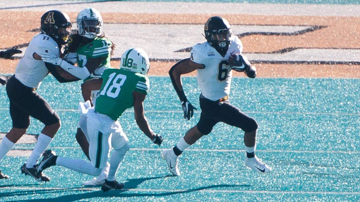Appalachian State running back Camerun Peoples (6) runs past North Texas defensive back Upton Stout (18). Peoples gained 319 yards and scored five touchdowns on 23 carries.
