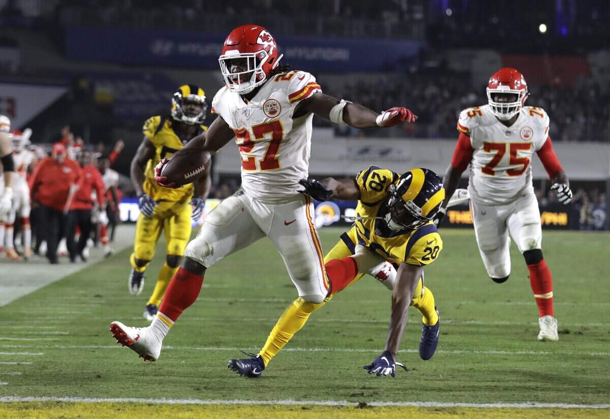 FILE - In this Nov. 19, 2018, file photo, Kansas City Chiefs running back Kareem Hunt (27) scores a touchdown ahead of Los Angeles Rams free safety Lamarcus Joyner (20) as Chiefs offensive guard Cameron Erving (75) looks on during the first half of an NFL football game, in Los Angeles. The Cleveland Browns have signed Kareem Hunt, the running back cut by Kansas City in November after a video showed him pushing and kicking a woman the previous February. Cleveland general manager John Dorsey, who drafted Hunt while working for Kansas City, on Monday, Feb. 11, 2019, said the Browns “fully understand and respect the complexity of questions and issues in signing a player with Kareem’s history and do not condone his actions.” (AP Photo/Marcio Jose Sanchez, File)