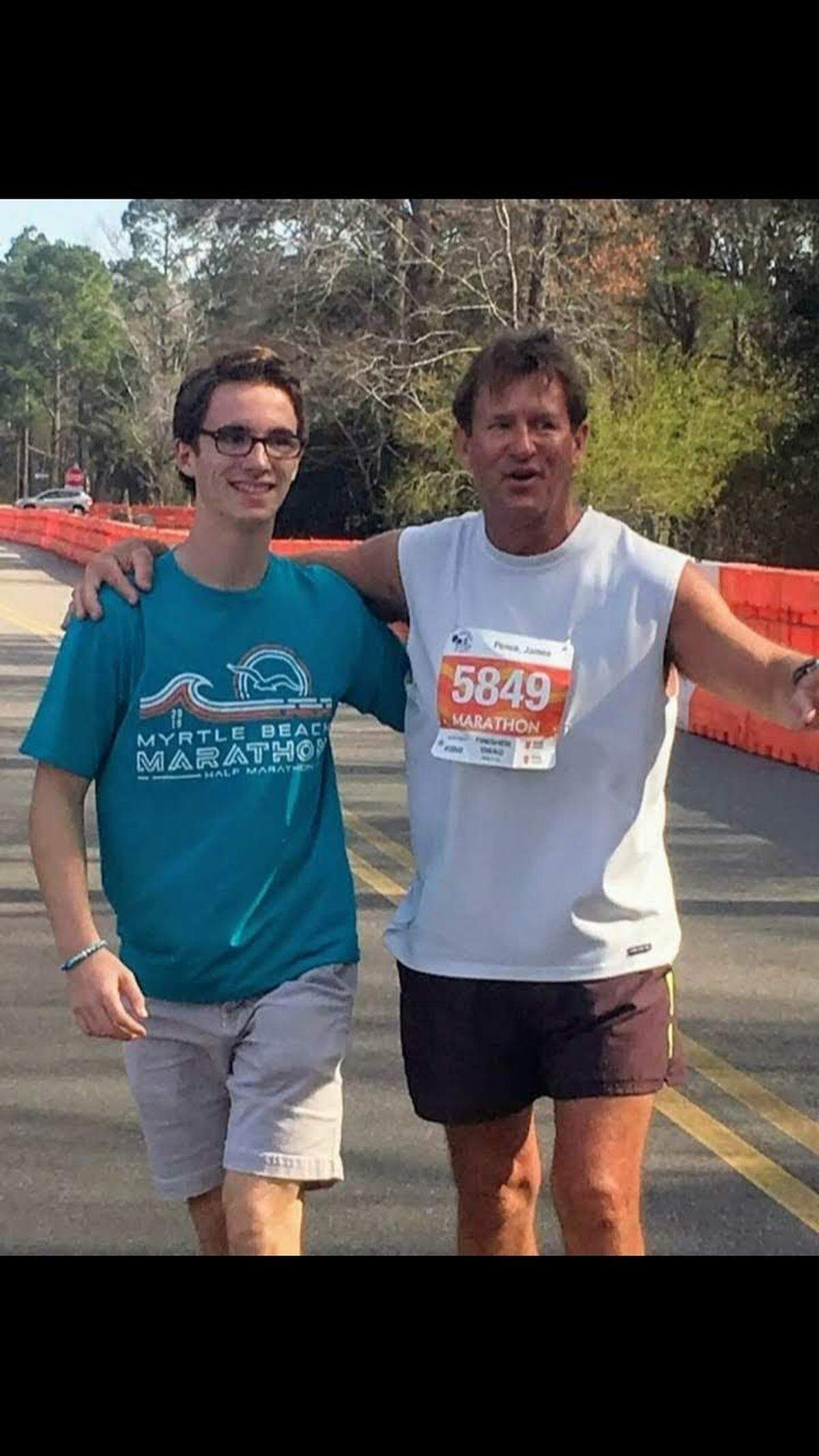Jim Pence poses with son Nick after they crossed the finish line of the 2019 Myrtle Beach Marathon.