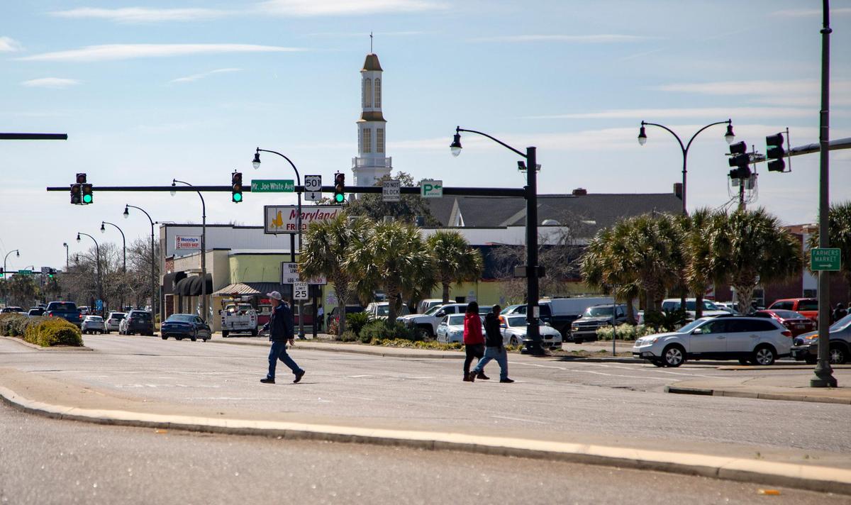Pedestrians cross Kings Highway in Myrtle Beach Friday along Mr. Joe White Avenue.