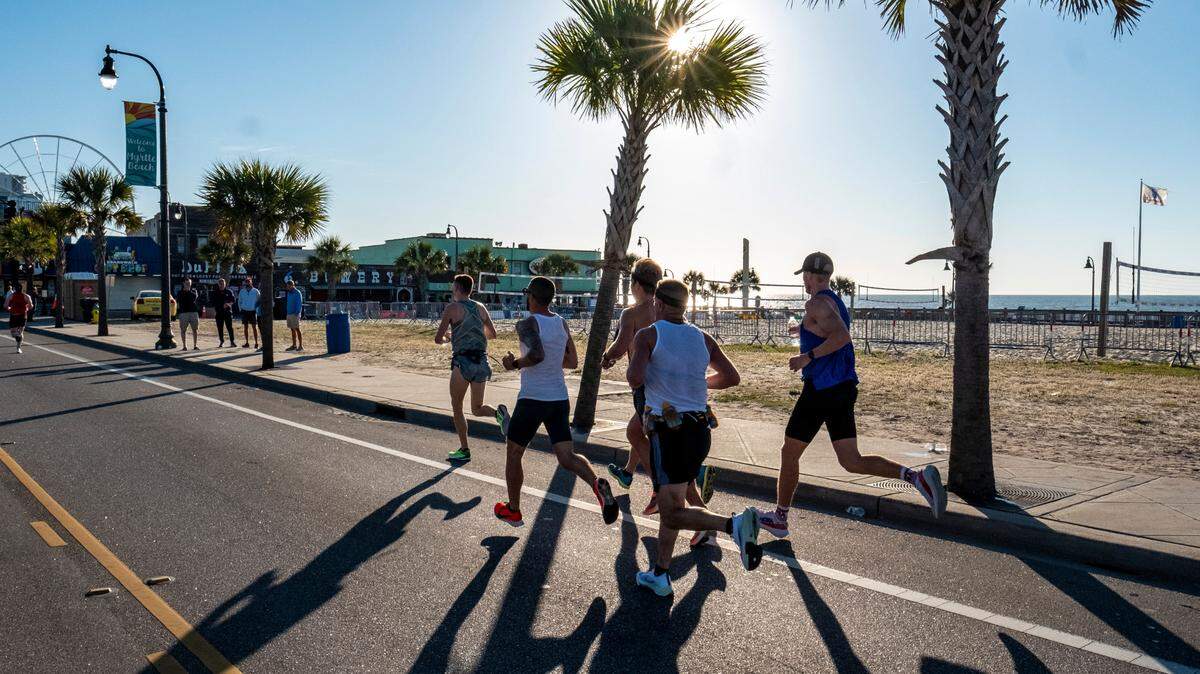 A group of runners pass a largely empty boardwalk on Ocean Boulevard. The annual Myrtle Beach Marathon is scheduled for Saturday, March 5, 2022.