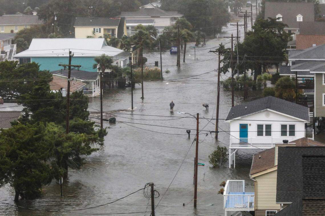 A North Myrtle Beach resident walks through flood waters as Hurricane Ian's storm surge inundates the area. Friday, September 30, 2022.