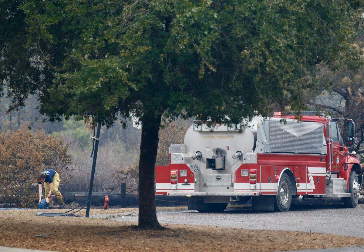 Fire crews are staging equipment ahead of the storm in Walkers Woods in hopes of containing the Carolina Forest wildfire. Residents have sprinklers watering lawns, houses and nearby wooded areas. The blaze enters its fifth day and impacts more than 2,000 acres of land with strong winds and occasional rain possible March 5, 2025.
