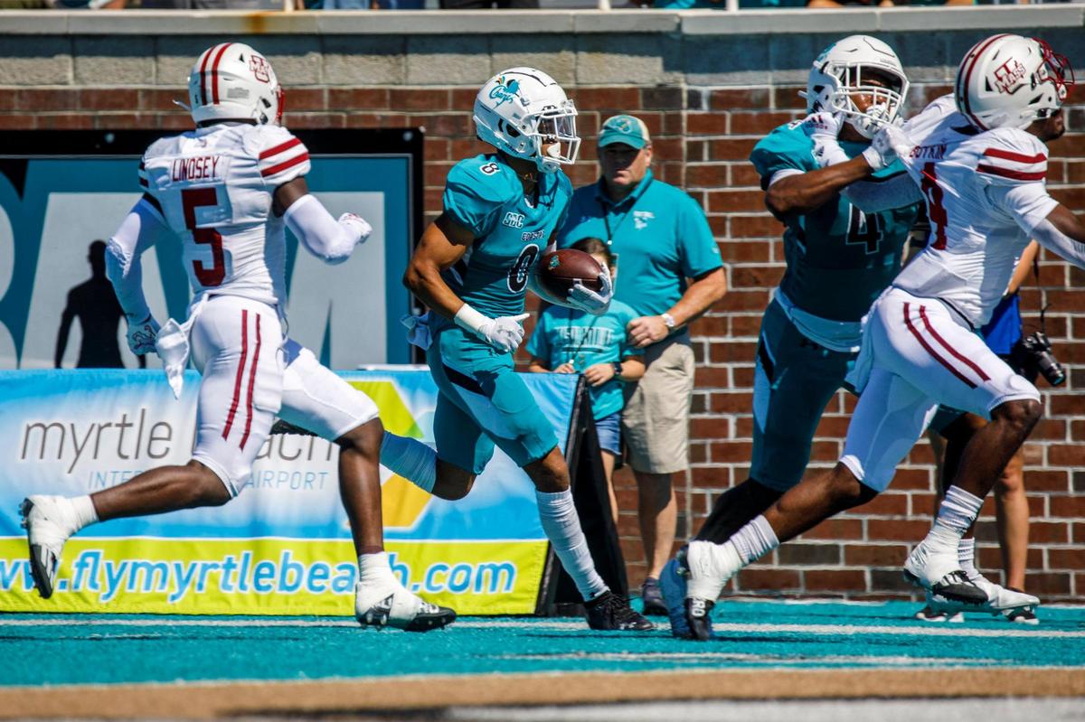 Coastals Tyson Mobley races down the sideline for a touchdown on Saturday. Coastal Carolina, ranked 17, defeated Massachusetts on Saturday at Brooks Stadium in Conway SC. Spectators were encouraged to wear teal for a “teal out” promotion. Aug. 11, 2021.