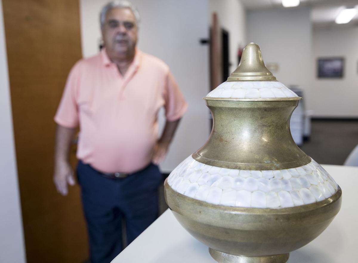Horry County Coroner Robert Edge inspects an ornate urn found by a lifeguard in the edge of the ocean in Myrtle Beach yesterday. The remains have not yet been identified. July 31, 2018.