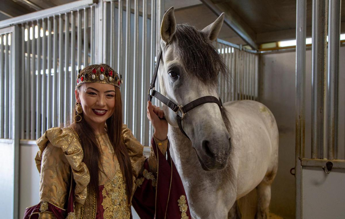 Chloe Hudson, who plays the first queen of the Medieval Times castle in the production company’s new show, stands with her horse Hipnotico backstage at Medieval Times in Myrtle Beach.