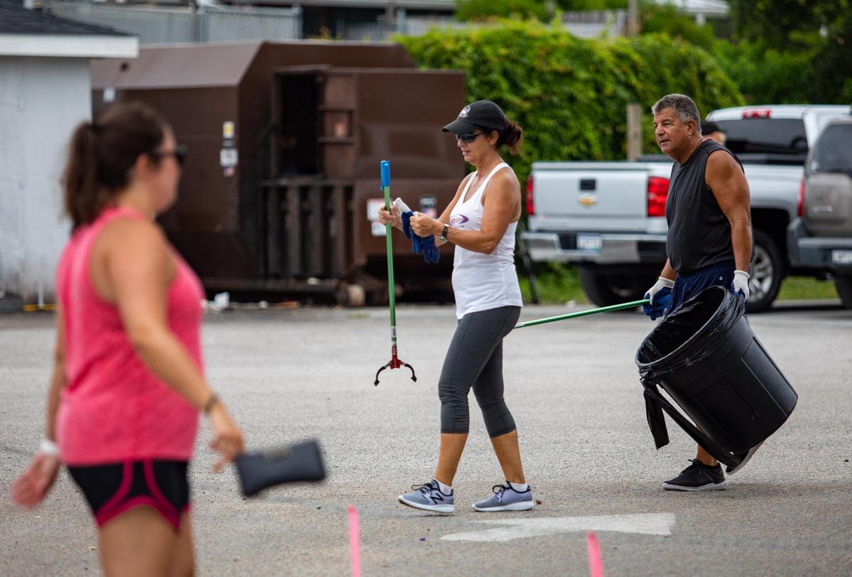 Volunteers return equipment to a volunteer table after picking up trash left over from Thursday evening’s July 4 festival at the Murrells Inlet MarshWalk.