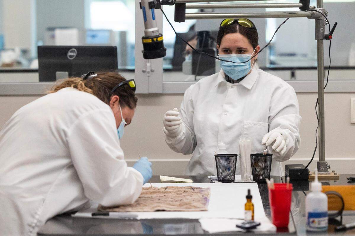 SLED workers take possible evidence from a clothe at their new forensics laboratory on Thursday, April 27, 2023.