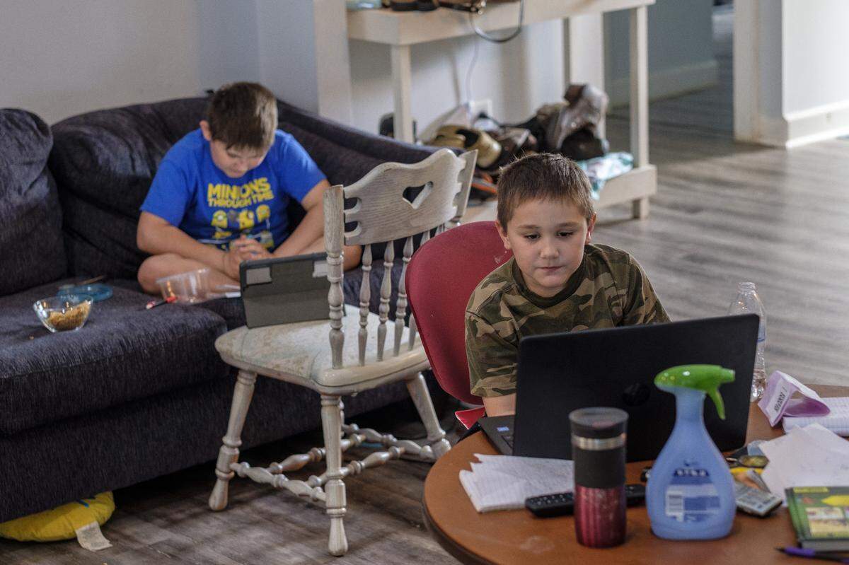 Lakewood Elementary students Costa (10) and David Koullias (8) work on school work in the family den. The coronavirus pandemic has required their father, Nick, a restaurant worker, and mother Melissa, a baker, to become school teachers while they self quarantine at home. April 1, 2020