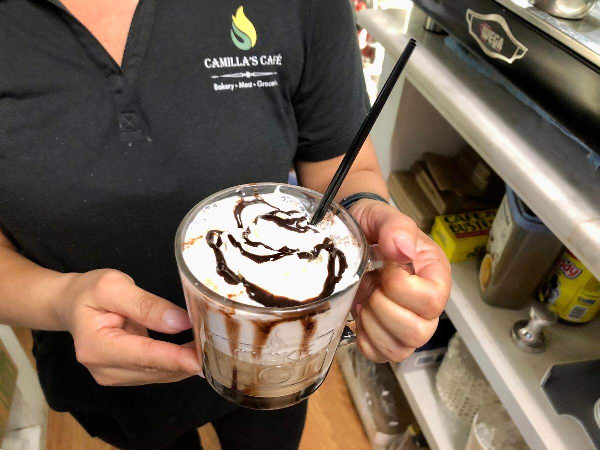 Camila’s Cafe employee Patricia da Silva shows a mocha cappuccino at the Brazilian restaurant. Coffee fans in Myrtle Beach, S.C. can try brews from around the world for National Coffee Day. Sept. 27, 2023.