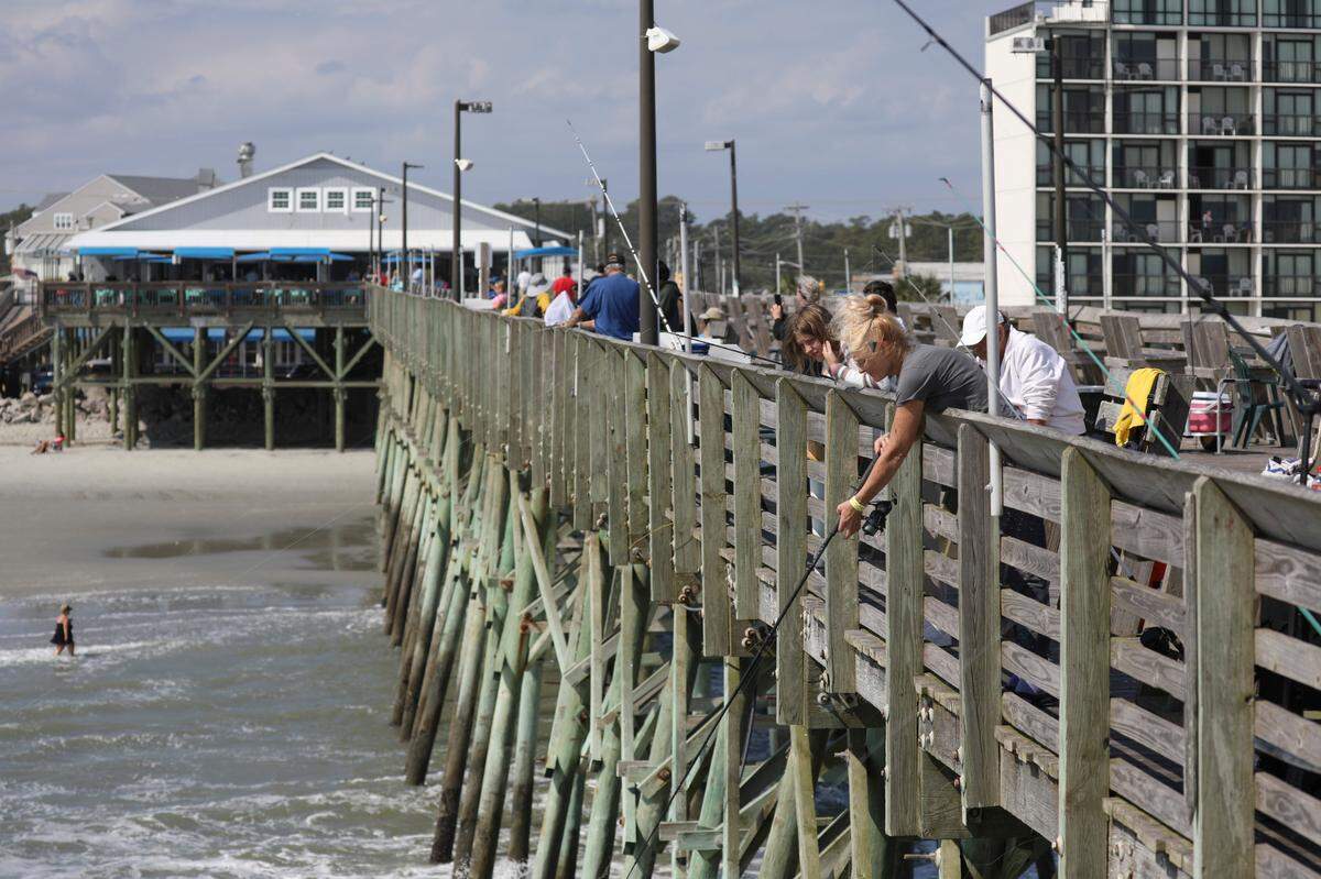 Crowds fish off the side of the Garden City Pier. Myrtle Beach area piers took a battering from Hurricane Ian this year but a strong pier culture prevails drawing fisherman and tourist back year after year. October 10, 2022.
