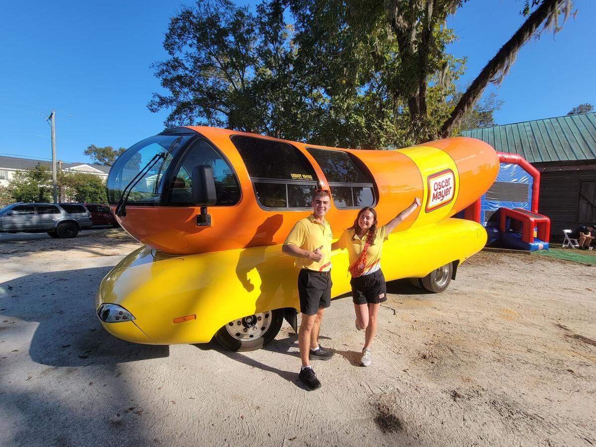Hotdoggers Cooper “Coop Dog” Albert and Kaitlyn “Corn Dog Kate” Goldstein pose with the Oscar Mayer Wienermobile at the Cooper House’s trunk-or-treat on Halloween.