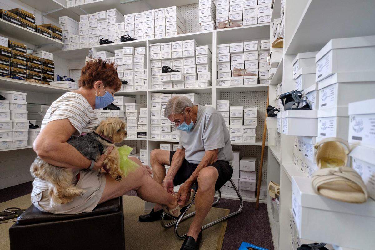Lanny Elmore fits Jan Vann with a pair of dancing shoes while she holds her dog Carley. Judy’s House of Oldies in North Myrtle Beach announced plans to close today due to decreased sales in the wake of the coronavirus after nearly thirty years of serving the dance community in North Myrtle Beach, S.C. July 14, 2020.