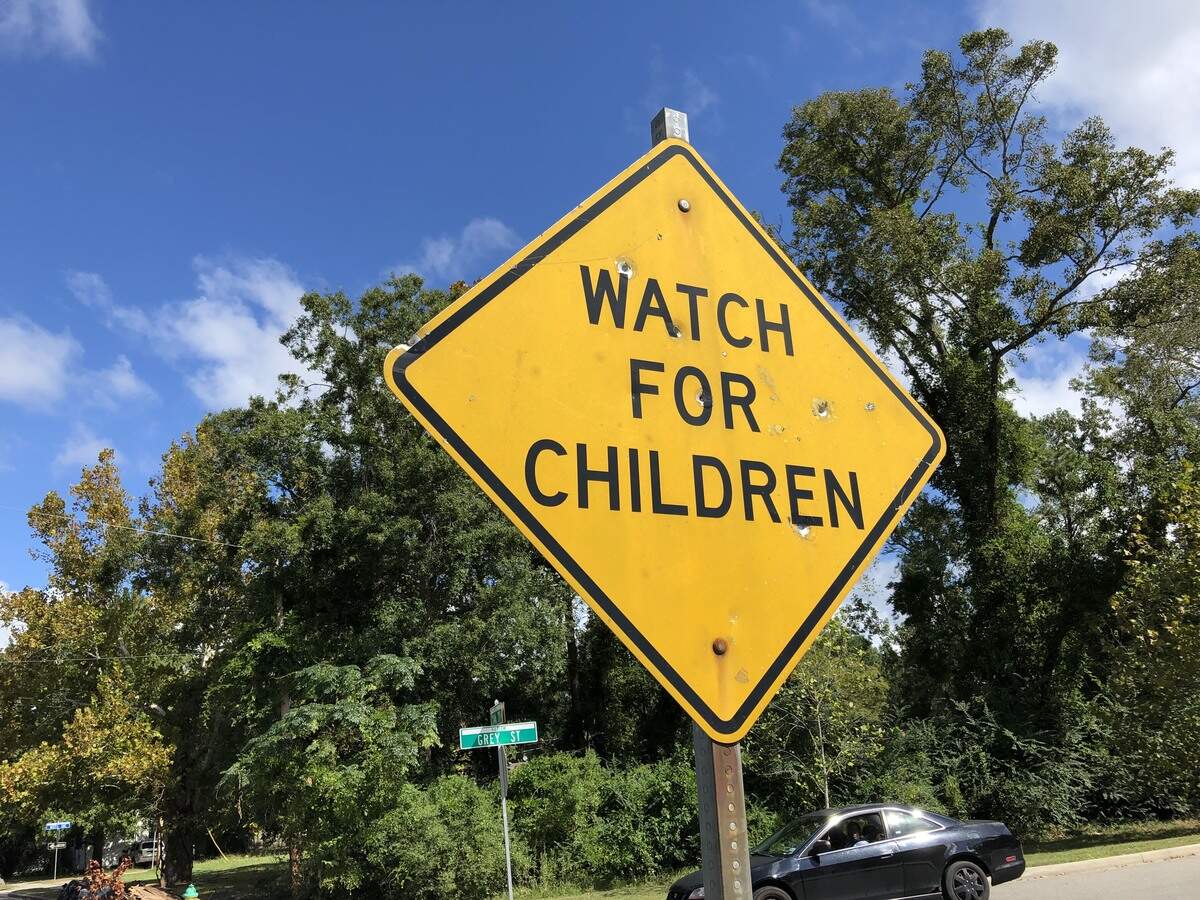 Officers examined fresh bullet holes in a “Watch for children” sign at the intersection of Canal and Grey streets.