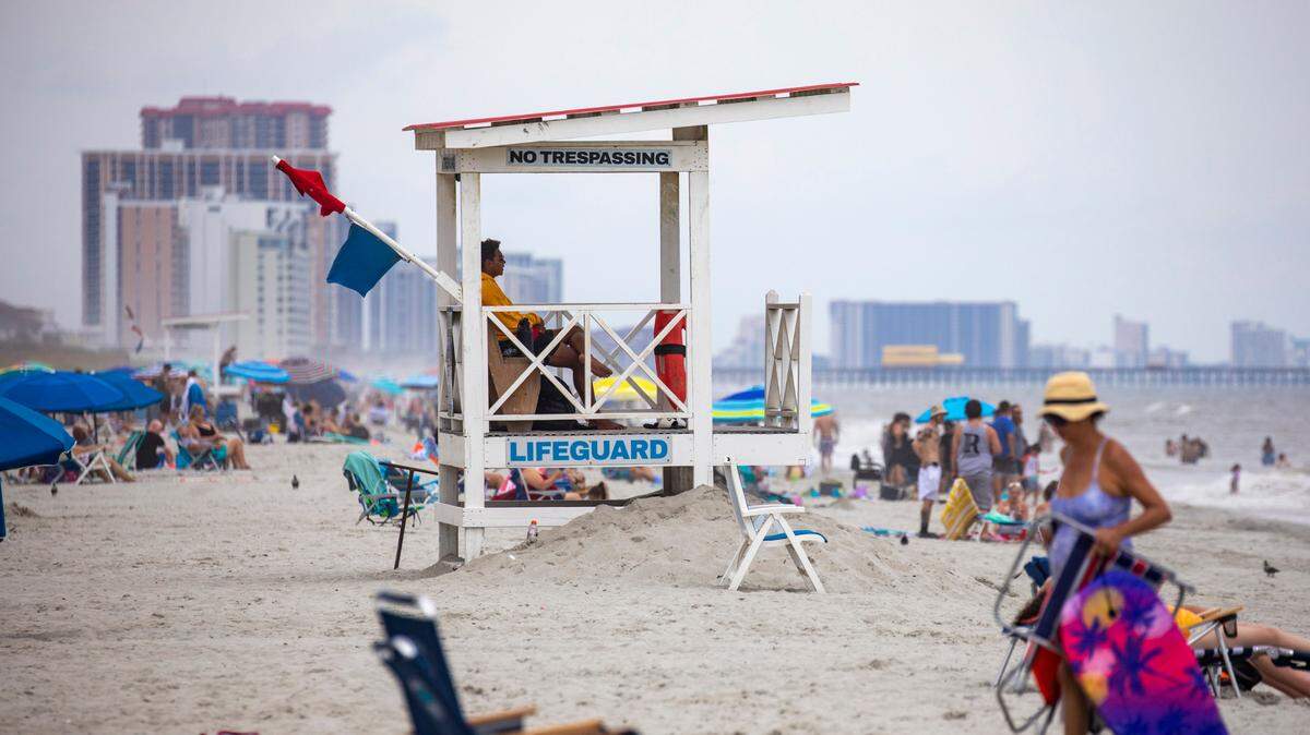 A lifeguard sits in a stand overlooking swimmers at 69th Avenue North in Myrtle Beach on Monday.Aug. 22, 2022.